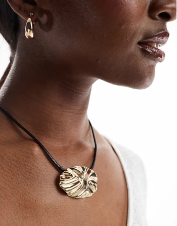 necklace with textured circle pendant and cord design in gold tone