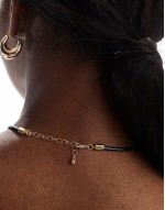 necklace with textured circle pendant and cord design in gold tone